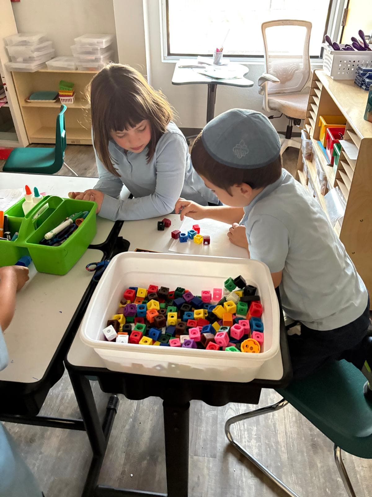 Students exploring math with colorful counting cubes
