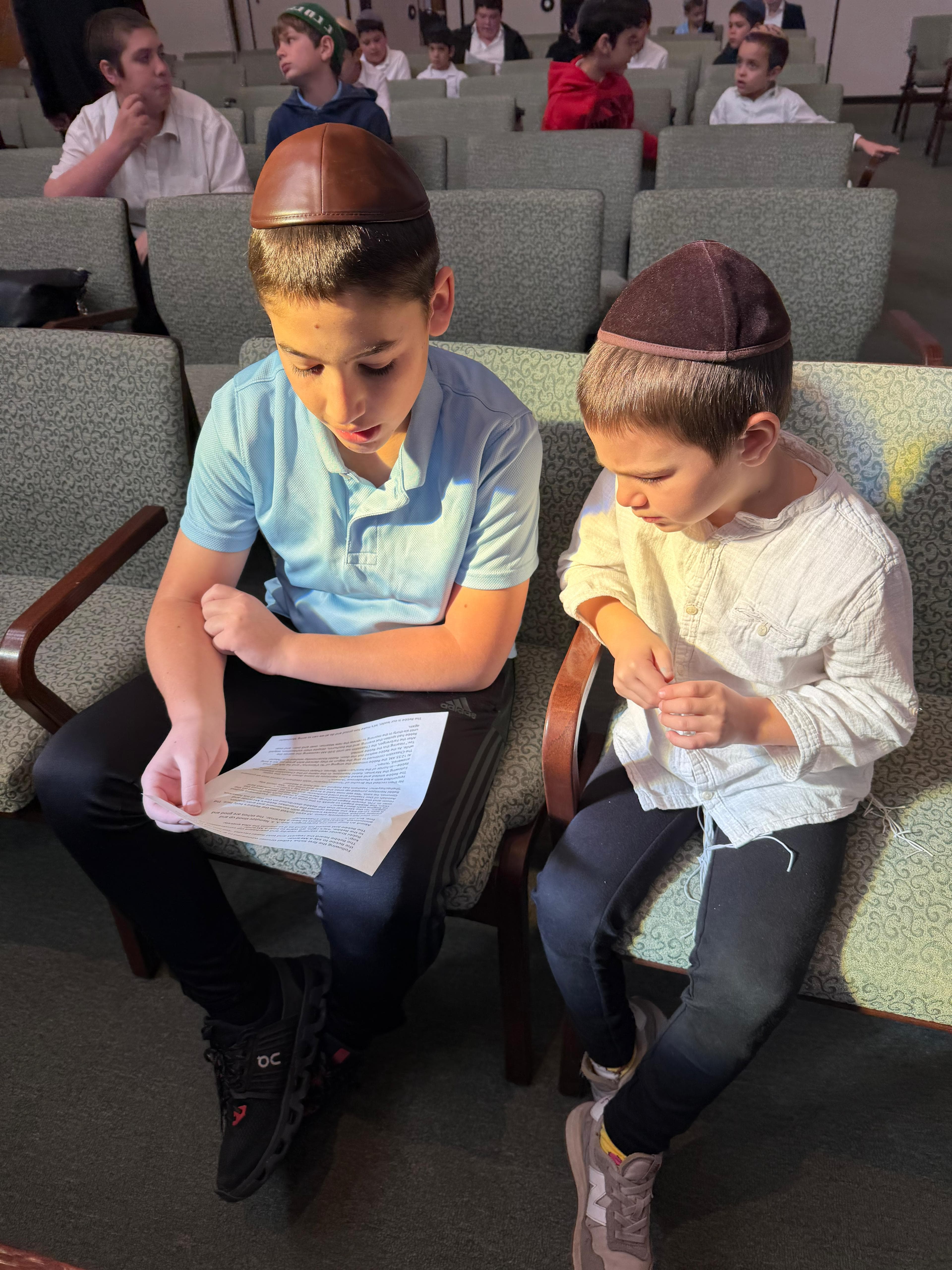 Two boys learning from a sheet together